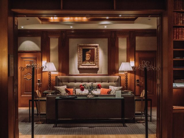 brown wooden bed frame with white and red floral bed linen