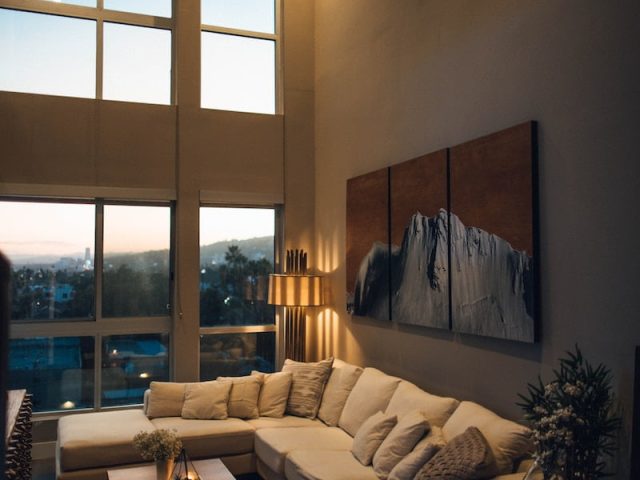 gray padded chaise couch beside window